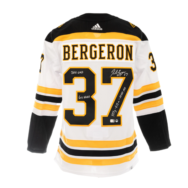 (PAST AUCTION) <br> LOT 39: PATRICE BERGERON AUTOGRAPHED AND 3X INSCRIBED WHITE ADIDAS AUTHENTIC JERSEY